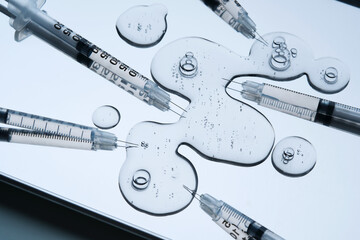 Syringes for injection and a drop of the drug in the tray.