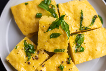 Fermented Maharashtrian Dhokla on a wooden plate with chopped fresh cilantro and lemon wedges, Fermented food, Fermentation