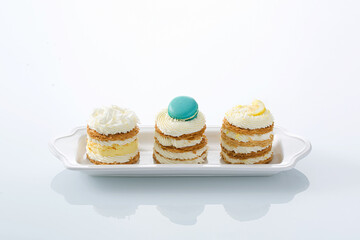 Assortment of Individual Mille-Feuille Pastries with Vanilla, Macaron, and Lemon Toppings on White...