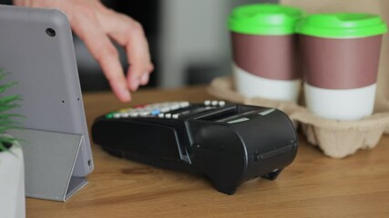 Close-up in the cafe man makes coffee for a customer which pay using credit card contactless payment spending money in cafe with digital transaction service. - Powered by Adobe