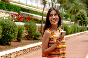 Naklejka premium Tourist enjoying summer holidays, happily using a mobile phone app while relaxing in a beautiful resort surrounded by vibrant nature