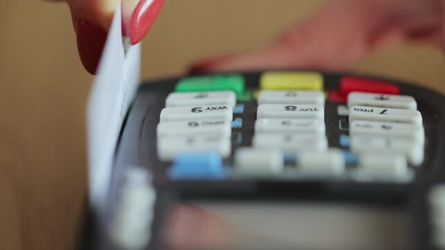 Credit card machine for money transaction. Close up of woman hand with credit card swipe through pos terminal and enter pin code. Banking services of electronic money. Financial success and safety.