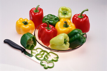 Vegetable colourful capsicum and slices with knife on white background