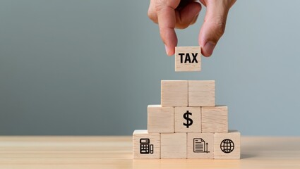 Tax planning strategy concept hand placing wooden block with tax word on top of pyramid