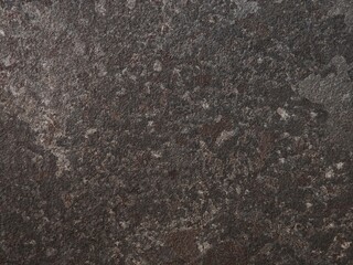 Close-up view of textured stone surface revealing earthy tones and natural patterns in a dimly lit environment