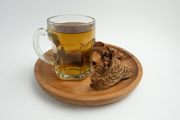 A glass of herbal decoction of Bajakah wood for alternative medicine.