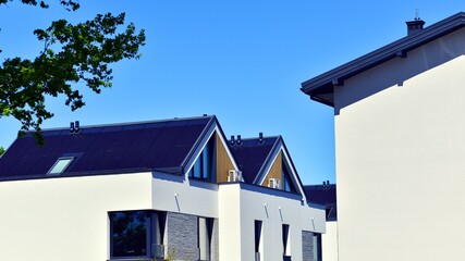 Residential homes with modern facade. Terraced family homes in newly developed housing estate. The real estate market in the suburbs. New single family houses in a new development area. 