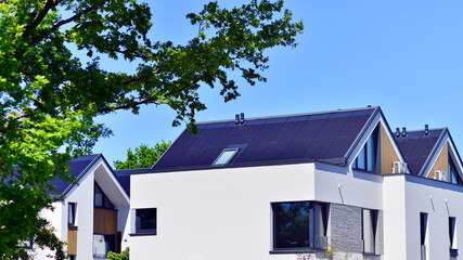 Residential homes with modern facade. Terraced family homes in newly developed housing estate. The real estate market in the suburbs. New single family houses in a new development area. 