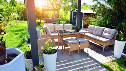 Modern aluminum pergola with stylish garden furniture in a beautiful garden.