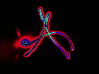 Glowing English letter A. On a black background with colored neon lines, a letter of the English alphabet is written by hand. The letter glows pink-red, creating a green-blue halo around it.