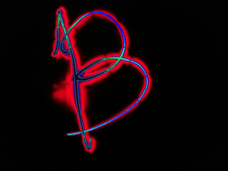 Glowing English letter B. On a black background with colored neon lines, a letter of the English alphabet is written by hand. The letter glows pink-red, creating a green-blue halo around it.