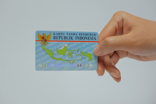 Malang, Indonesia -  06 30 2023 : Young Asian woman hand holding Indonesian national identity card. KTP