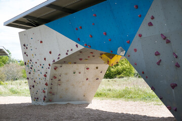 Climbing wall, colorful fixtures attached to the wall.
