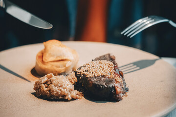 Gourmet veal cheek with mustard seeds and apple puree on a large plate, fine dining presentation