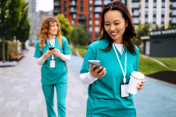 Healthcare professionals engage in conversation while walking in a modern urban environment during...