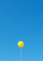 AI-Generated of Minimalist Concept with Negative Space with Yellow Balloon in Blue Sky