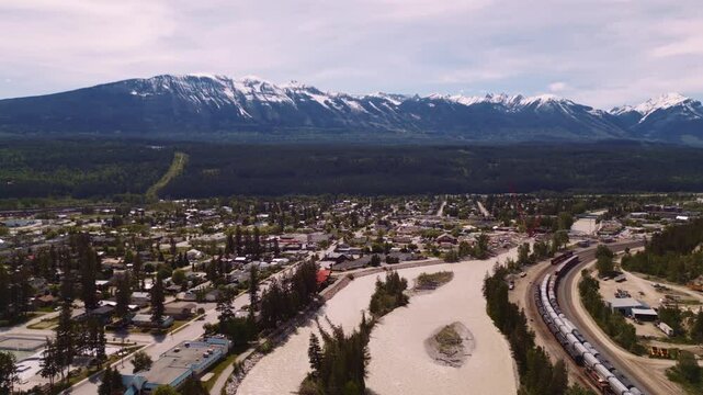 Drone moves forward over Golden, BC, revealing the mountain town, forests, and scenic Columbia Valley landscape nestled between the Rockies and Purcells.