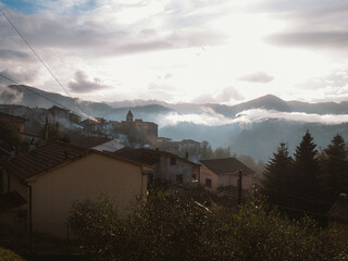 Foggy Morning in Mountain Village with Cloudy Sky