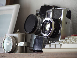 Vintage film cameras on a wooden table with soft natural lighting. Perfect for retro photography,...
