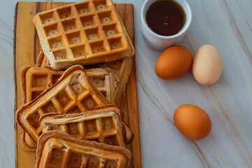 Freshly made waffles served with seasonal fruits and syrup – delicious homemade breakfast