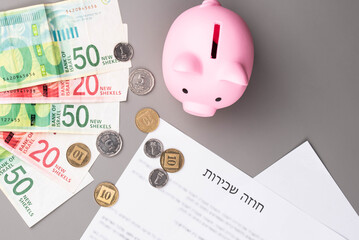 Rental or Residential Lease agreement contract in Hebrew and piggy bank. Short and long term rentals in Israel, housing searching crisis, signing lease agreement, and rising prices.