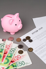 Rental or Residential Lease agreement contract in Hebrew and piggy bank. Short and long term rentals in Israel, housing searching crisis, signing lease agreement, and rising prices.