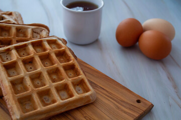 Freshly made waffles served with seasonal fruits and syrup – delicious homemade breakfast