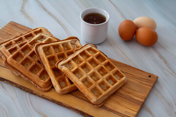 Freshly made waffles served with seasonal fruits and syrup – delicious homemade breakfast