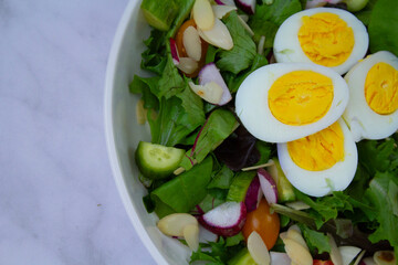 Fresh and vibrant homemade salad topped with sliced eggs and a light vinaigrette