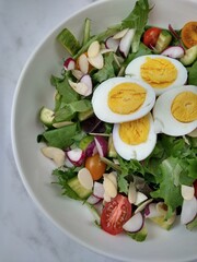 Fresh and vibrant homemade salad topped with sliced eggs and a light vinaigrette