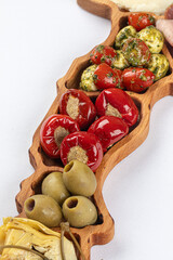 Wooden platter of starter appetizers with olives and pepper