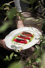 Holding portion of baked pepper appetizer with small fish