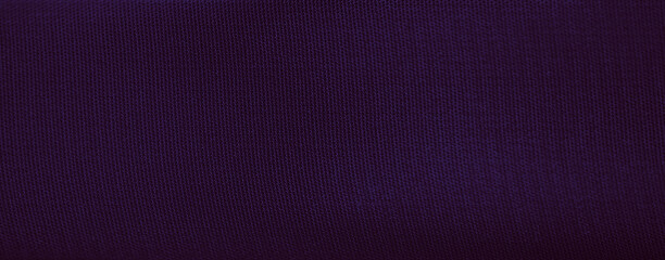 Blur of deep purple fabric with luxurious folds and flowing texture. The shadows and highlights add artistic detail to the softly curved material.