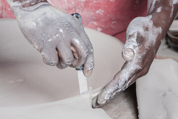 Fototapeta premium strong active hands working with pottery during the glazing process textured 