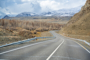 Mountain road and valley of Chuysky Trakt Altai Russia. Scenic route through rugged terrain and expansive natural landscape