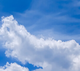 Obraz premium Long white clouds stretch across a clear blue sky with a few wispy clouds.