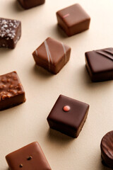 Minimal overhead shot of chocolate squares on beige background, elegant candy dessert composition