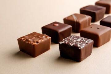 Minimal overhead shot of chocolate squares on beige background, elegant candy dessert composition