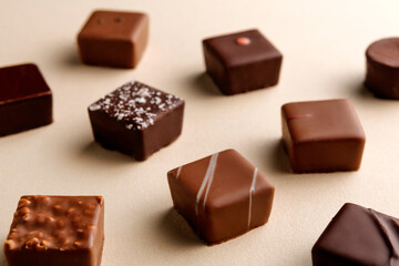 Minimal overhead shot of chocolate squares on beige background, elegant candy dessert composition