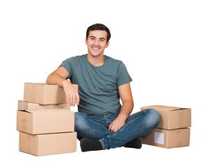 Excited young man sitting on the floor leans on cardboard boxes ready to move, imagining himself in a new house. Male packing stuff and resting on the floor