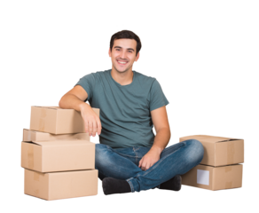 Excited young man sitting on the floor leans on cardboard boxes ready to move, imagining himself in a new house. Male packing stuff and resting on the floor