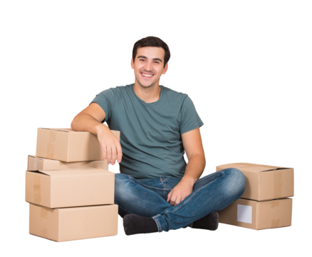 Excited young man sitting on the floor leans on cardboard boxes ready to move, imagining himself in a new house. Male packing stuff and resting on the floor