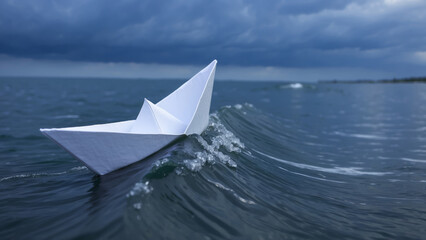 Obraz premium A paper boat sails across the sea, creating a sense of journey and adventure