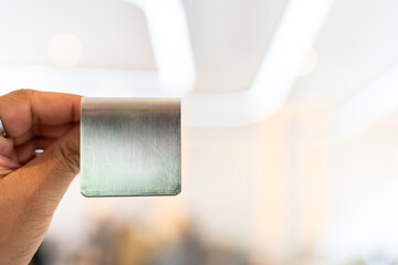 Hand holding blank aluminium number sign at restaurant