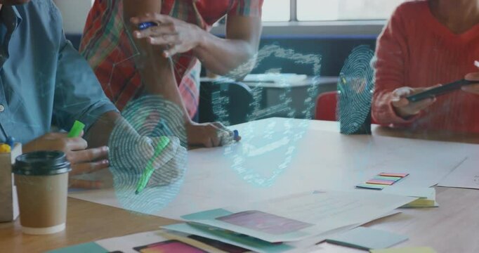 Picking green highlighter, UX team sketching UI mockups at table, spawning animated security icons