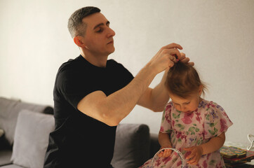 father doing haircut for child girl at home