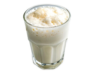 Chilled ayran yogurt drink with foamy top in clear glass on white surface