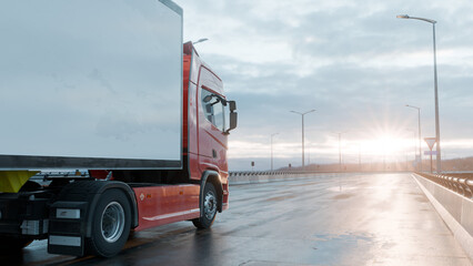 Red Cargo Truck Driving on Wet Highway at Sunrise – Freight Transport Concept