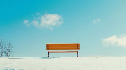 Solitary bench in snowy expanse under a vibrant blue sky during winter