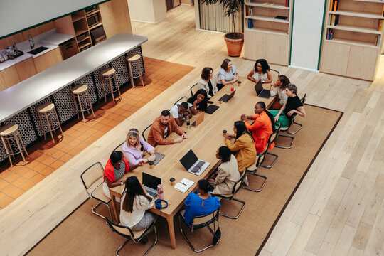 Top-view of creative professionals having a collaborative meeting with laptops and coffee